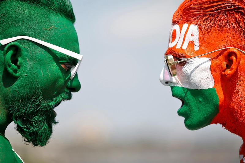 With their faces painted in the Indian and Pakistani national flag colours, eager cricket fans in Ahmedabad face-off for a picture ahead of the first match between India and Pakistan in Twenty20 World Cup super 12 stage to be held tonight in Dubai, October 24, 2021. Heightened tension and expectations are rife as the mother of all rivalries gets played out after three years, when the two teams met last.