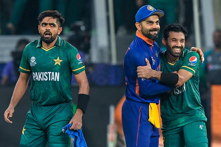 India’s captain Virat Kohli (C) congratulates his Pakistan counterpart Babar Azam (L) and Mohammad Rizwan following their victory during the ICC Men"s Twenty20 World Cup cricket match between India and Pakistan at the Dubai International Cricket Stadium in Dubai on October 24, 2021.