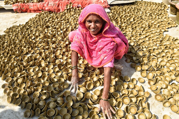 Anticipating festival sales leading up to Diwali, a potter puts earthen lamps out to dry in Chinhat area, Lucknow. This extended family of 30, including children, work together to make the lamps, October 27, 2021.