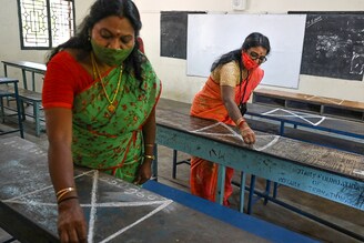 Teachers make social distancing markers on classroom benches at a school as they prepare for reopening after the Covid-19 lockdown relaxation in Chennai on August 31, 2021. On hearing a public interest litigation, the Tamil Nadu government informed the Madras High Court that school students would not be compelled to attend physical classes and can opt for online classes as an alternative.