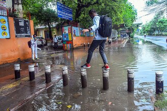 Students wade through a waterlogged stretch after heavy rain at Sarvodaya Vidyalaya, Matasundari School, Deen Dayal Upadhaya Marg, on September 1, 2021 in New Delhi, India. The Delhi Disaster Management Authority in an order on Monday permitted schools, colleges, technical and training institutes, coaching institutes, and libraries to re-open for students from class IX and above, and issued a detailed SOP for the same.
