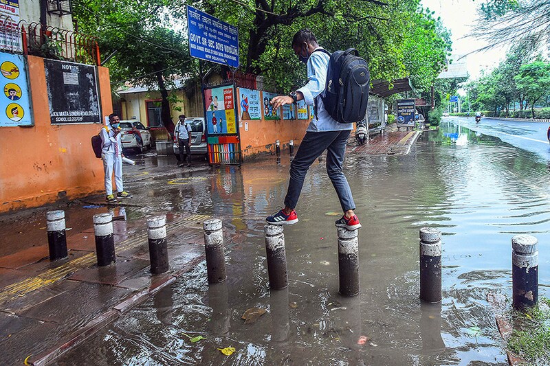 Students wade through a waterlogged stretch after heavy rain at Sarvodaya Vidyalaya, Matasundari School, Deen Dayal Upadhaya Marg, on September 1, 2021 in New Delhi, India. The Delhi Disaster Management Authority in an order on Monday permitted schools, colleges, technical and training institutes, coaching institutes, and libraries to re-open for students from class IX and above, and issued a detailed SOP for the same.