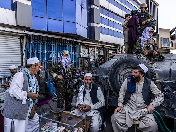 Taliban fighters guard money-changers outside the main currency exchange market in Kabul. The Taliban has long tapped informal lenders and opium to fund Afghanistan’s insurgency. Image: Victor J. Blue/The New York Times