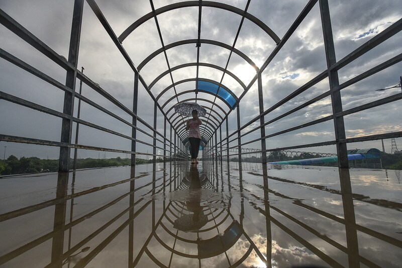 An overcast sky hovers over a commuter on the Laxmi Nagar walkway in New Delhi, September 13, 2021. With a highly unusual monsoon season this year, the national capital has received nearly 70 percent of its monsoon season rainfall during just 10 days of September. The rainfall is mainly due to consecutive and persistent low-pressure systems that formed in the Bay of Bengal this month.