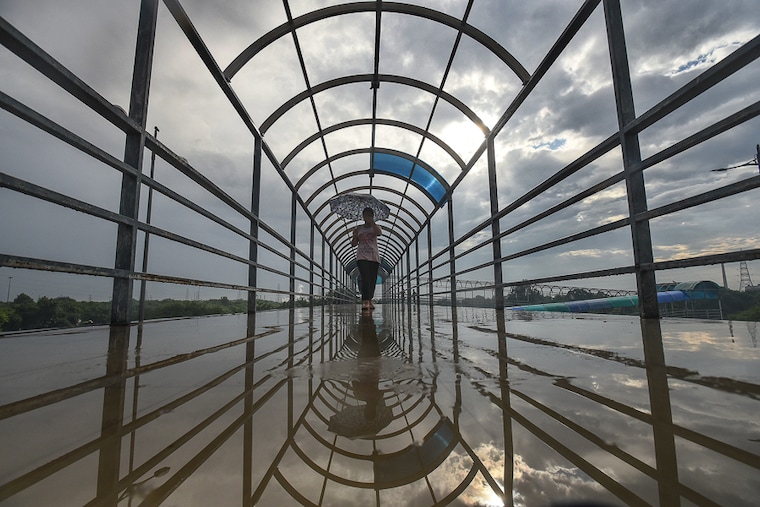 An overcast sky hovers over a commuter on the Laxmi Nagar walkway in New Delhi, September 13, 2021. With a highly unusual monsoon season this year, the national capital has received nearly 70 percent of its monsoon season rainfall during just 10 days of September. The rainfall is mainly due to consecutive and persistent low-pressure systems that formed in the Bay of Bengal this month.
