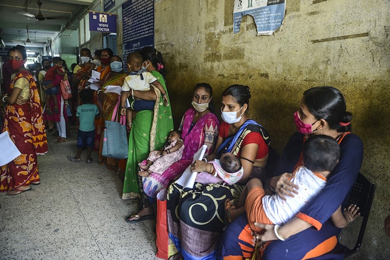 Following a surge in fever and respiratory problems in children, women with their children wait in front of a pediatric ward for a medical check-up at a hospital in Siliguri on September 15, 2021.