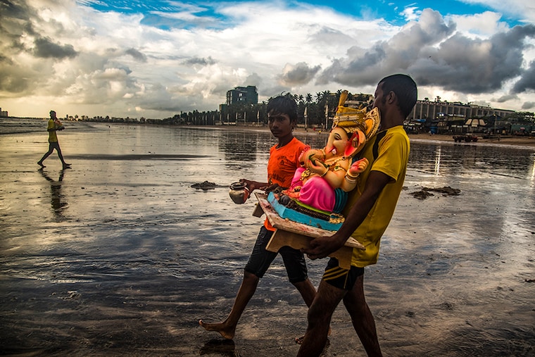 Volunteers take Ganpati idols for immersion on the last day of the Ganpati festival at Juhu beach, on September 19, 2021 in Mumbai, India.