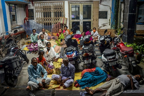 People camp overnight to receive a dose of Covid-19 coronavirus vaccine at a government-run district hospital at midnight in Siliguri on September 28, 2021.