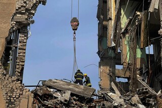 This handout picture released on March 30, 2022 by the State Emergency Service of Ukraine shows rescuers conducting search operations and dismantling the debris of a government building in Mykolaiv, which was hit by Russian rockets the previous day. (Credit: Ukrainian State Emergency Service / AFP)