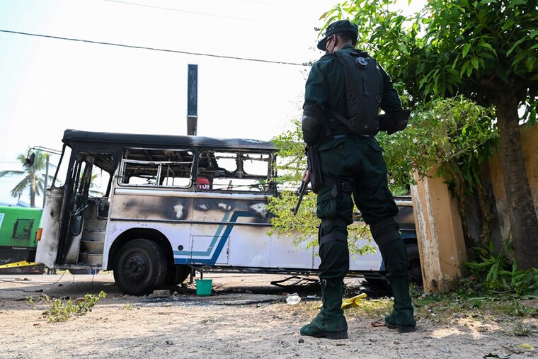 A soldier guards an area next to a burnt-out bus near the Sri Lankan president"s home in Colombo on April 1, 2022. - Security forces were deployed across the Sri Lankan capital on April 1 after protesters tried to storm the president"s home in anger at the nation"s worst economic crisis since independence. (Credit: Ishara S. KODIKARA / AFP)