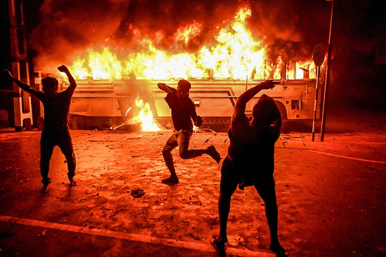 Protesters shout slogans after setting a bus on fire during a demonstration outside the Sri Lankan president"s home to call for his resignation in Colombo on March 31, 2022. - Security forces were deployed across the Sri Lankan capital on April 1 after protesters tried to storm the president"s home in anger at the nation"s worst economic crisis since independence.