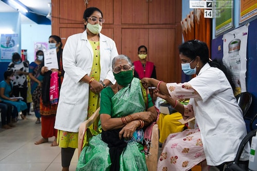 A health worker inoculates a woman with a third "booster" dose of the Covid-19 coronavirus vaccine in Hyderabad on January 10, 2022, as the country sees an Omicron-driven surge in cases. (Credit: Noah SEELAM / AFP)