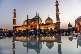 A reflection of illuminated Jama Masjid during the month of Ramadan in Old Delhi on April 3, 2022. Muslim devotees gather at sunset in Jama Masjid, Old Delhi, to break their fast during the month of Ramadan. Jama Masjid is one of the largest and oldest mosques in India.
