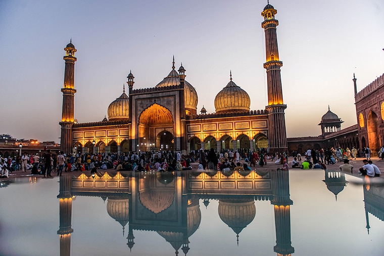 A reflection of illuminated Jama Masjid during the month of Ramadan in Old Delhi on April 3, 2022. Muslim devotees gather at sunset in Jama Masjid, Old Delhi, to break their fast during the month of Ramadan. Jama Masjid is one of the largest and oldest mosques in India.