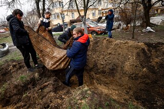 Serhii Lahovskyi, 26, and other residents carry the body of Ihor Lytvynenko to bury him at the garden of residential buildingâ€‹. According to residents, Ihor was killed by Russian soldiers beside a building"s basement, amid Russia"s invasion of Ukraine, in Bucha, Ukraine April 5, 2022. (Credit:&nbspZohra Bensemra / Reuters)