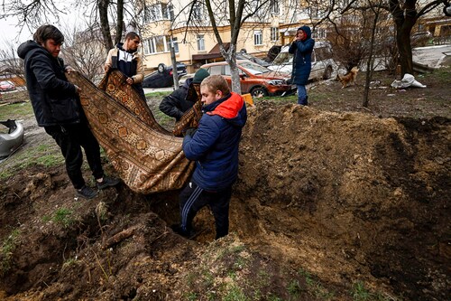 Serhii Lahovskyi, 26, and other residents carry the body of Ihor Lytvynenko to bury him at the garden of residential buildingâ€‹. According to residents, Ihor was killed by Russian soldiers beside a building"s basement, amid Russia"s invasion of Ukraine, in Bucha, Ukraine April 5, 2022. (Credit:&nbspZohra Bensemra / Reuters)