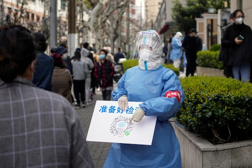 A worker in a protective suit shows a QR code to residents lining up for nucleic acid testing, as the second stage of a two-stage lockdown to curb the spread of the coronavirus disease (COVID-19) begins in Shanghai, China April 1, 2022.  (Credit: Aly Song / Reuters) A worker in a protective suit shows a QR code to residents lining up for nucleic acid testing, as the second stage of a two-stage lockdown to curb the spread of the coronavirus disease (COVID-19) begins in Shanghai, China April 1, 2022.  (Credit: Aly Song / Reuters)