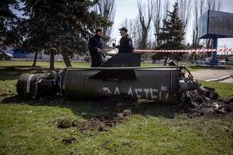 Ukrainian police inspect the remains of a large rocket with the words "for our children" inscribed in Russian next to the main building of a train station that was being used for civilian evacuations in Kramatorsk, eastern Ukraine on April 8, 2022. The station was hit by a rocket attack, killing at least 35 people.