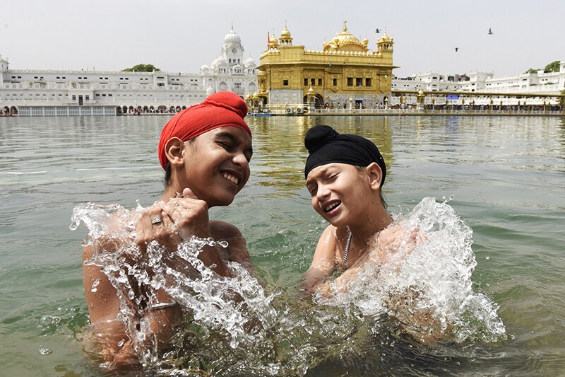 Sikh devotees take a bath in the sacred pond on the occasion of Baisakhi" a spring harvest festival for Sikhs and Hindus, at the Golden Temple in Amritsar on April 14, 2022.