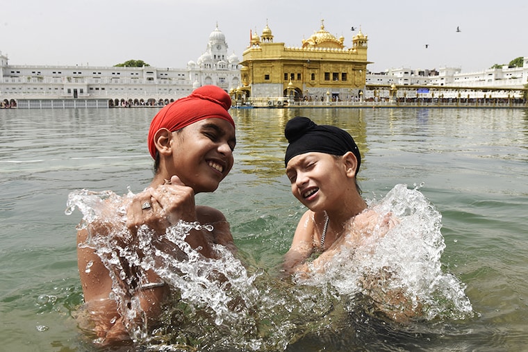 Sikh devotees take a bath in the sacred pond on the occasion of Baisakhi" a spring harvest festival for Sikhs and Hindus, at the Golden Temple in Amritsar on April 14, 2022.