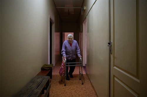 An elderly woman walks in a hallway at the Mercy House shelter for people in need, on the outskirts of Dnipro on April 15, 2022. The elderly are "often forgotten, very vulnerable" during conflicts, says Federico Dessi, the director for Ukraine of the NGO Handicap International, which is providing equipment and financial support to the Dnipro shelter. (Credit: Ed JONES/ AFP)