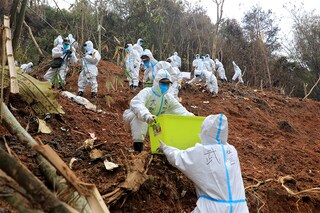 This photo taken on March 26, 2022 shows paramilitary police officers transferring fragments of wreckage of the China Eastern passenger jet which crashed onto a mountainside in Tengxian county, Wuzhou city, in China"s southern Guangxi region. The Boeing 737-800 was flying between the cities of Kunming and Guangzhou on March 21 when it nosedived into a mountainside, disintegrating on impact and killing all 132 people on board.