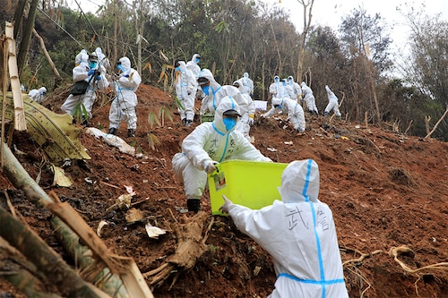 This photo taken on March 26, 2022 shows paramilitary police officers transferring fragments of wreckage of the China Eastern passenger jet which crashed onto a mountainside in Tengxian county, Wuzhou city, in China"s southern Guangxi region. The Boeing 737-800 was flying between the cities of Kunming and Guangzhou on March 21 when it nosedived into a mountainside, disintegrating on impact and killing all 132 people on board.