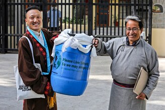 India"s climate activist Sonam Wangchuk (R) carries a container with a block of ice from the Khardung La glacier to be presented to the Tibetan spiritual leader the Dalai Lama on the occasion of the Earth Day at Tsuglakhang in McLeod Ganj on April 22, 2022.