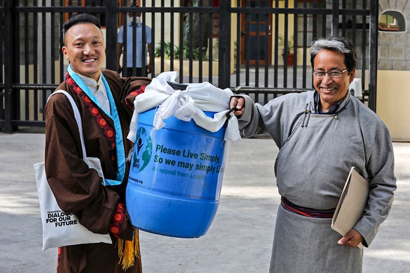 India"s climate activist Sonam Wangchuk (R) carries a container with a block of ice from the Khardung La glacier to be presented to the Tibetan spiritual leader the Dalai Lama on the occasion of the Earth Day at Tsuglakhang in McLeod Ganj on April 22, 2022.
