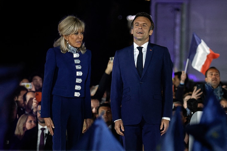 French President Emmanuel Macron reacts on stage next to his wife, French first lady Brigitte Macron, after being re-elected as president, following the results in the second round of the 2022 French presidential election, during his victory rally at the Champ de Mars in Paris, France, April 24, 2022.