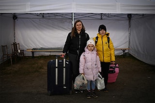 Ukrainian refugee Ganna Pastushenko (L), a 35-year-old accountant from Odessa, poses for a picture along with her children Timur (R), 11, and Dasha, (C), 6, as they wait for transportation after crossing the Ukrainian-Slovakian border into Slovakia at the Vysne Nemecke border crossing, eastern Slovakia. A heartbreaking human drama is playing out along Ukraine"s borders. (Credit: CHRISTOPHE ARCHAMBAULT / AFP)