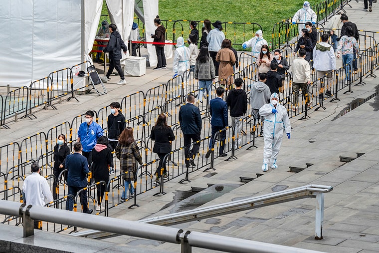 Security guards wear protective clothing as office workers queue for Covid-19 nucleic acid tests at a makeshift testing site on April 28, 2022, in Beijing, China. China is trying to contain a spike in coronavirus cases in the capital after dozens tested positive in recent days, prompting local authorities to initiate mass testing in most districts and to lock down some neighbourhoods where cases are found in an effort to maintain the country"s zero Covid strategy.