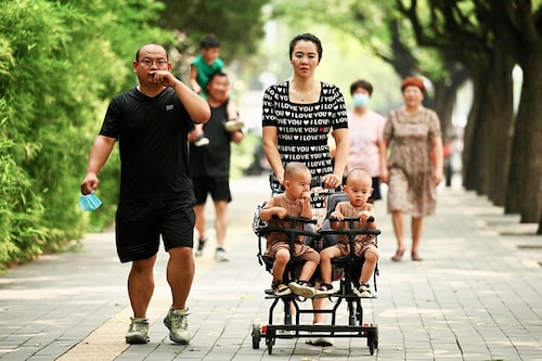 A woman pushes a trolley with twins along a street in Beijing on August 2, 2022. China"s population will begin to shrink by 2025, officials said, as family sizes grow smaller and citizens age. Image: Noel Celis / AFP A woman pushes a trolley with twins along a street in Beijing on August 2, 2022. China"s population will begin to shrink by 2025, officials said, as family sizes grow smaller and citizens age. Image: Noel Celis / AFP
