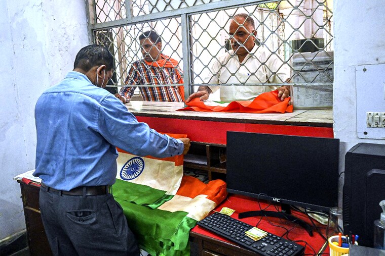 A customer buys an Indian national flag from a post office’s sales counter in New Delhi on August 2, 2022. As part of the celebrations to mark the 75th anniversary of the country’s independence, the flags are being sold at post offices and fair-price shops. The "Har Ghar Tiranga" campaign by Indian authorities urges citizens to display the flag at homes and on social media profiles.