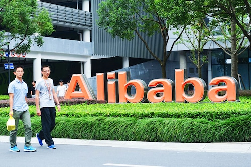 Staff members walk past a logo of Chinese ecommerce giant Alibaba at its headquarters in Hangzhou in China"s eastern Zhejiang province. Image: AFP / China OutÂ 