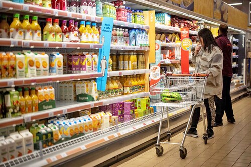 A customer shops for chilled fruit juice at a Sainsbury"s supermarket in Walthamstow, East London. Image:Tolga Akmen / AFP