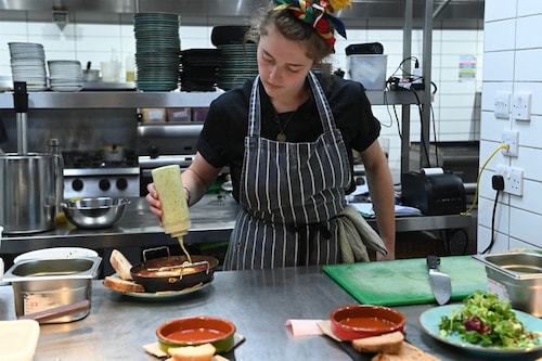 A member of staff prepares some food at The Canteen restaurant, one of the first in the UK to place the carbon footprint of its dishes on its menu besides the calories, in Bristol, on August 3, 2022. Image: Ashley Crowden / AFP A member of staff prepares some food at The Canteen restaurant, one of the first in the UK to place the carbon footprint of its dishes on its menu besides the calories, in Bristol, on August 3, 2022. Image: Ashley Crowden / AFP