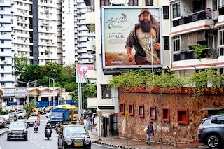 Vehicles drive past a poster of the upcoming Bollywood film "Laal Singh Chaddha" put up near a residential building in Mumbai on August 8, 2022. Image: AFP