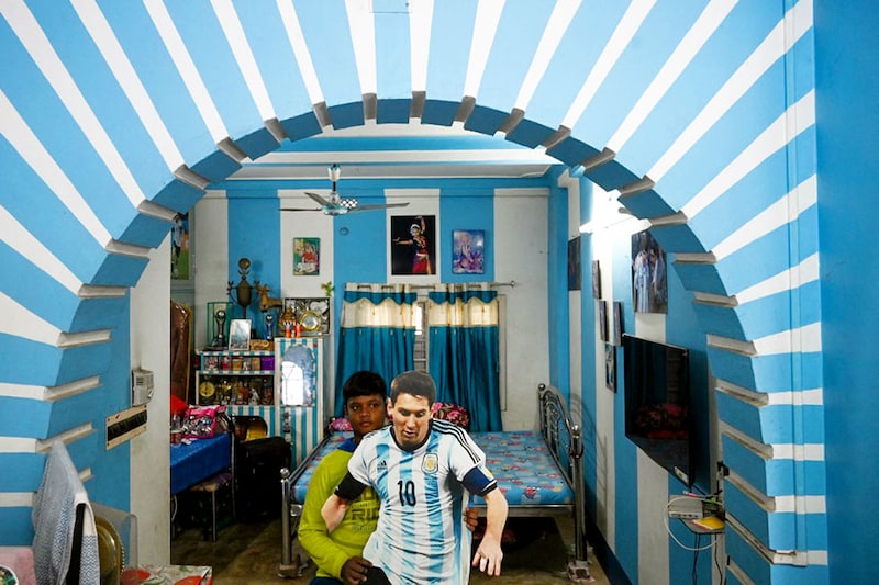 Suvam Patra, son of Argentina football fan Shib Shankar Patra, displays a portrait of Lionel Messi inside his house painted in the team’s colours, in Ichhapur, around 35 km north of Kolkata on December 12, 2022. Argentina faces Croatia in the semifinal match of the FIFA World Cup 2022 at 12.30 AM IST.