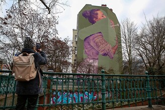 A Ukrainian woman takes a photo of a mural by the innerfields art collective titled "Absent," depicting a Ukrainian woman who lost a loved one to war, on December 16, 2022, in Berlin, Germany. Tens of thousands of Ukrainians are estimated to have been killed since Russia launched its large-scale invasion on February 24, but an official civilian or military death toll has not been given. Image: Adam Berry/Getty Images