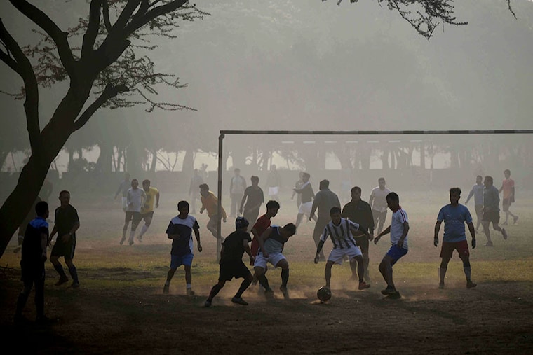 Boys playing football amid a cold and foggy morning at the sector-29 ground near Leisure Valley Park on December 19, 2022, in Gurugram, India. The maximum temperature in the National Capital region is expected to be around 26 degrees Celsius, with a low of approximately 6 degrees Celsius.