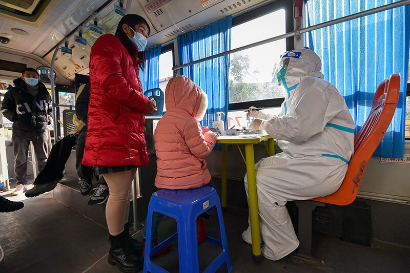 Doctors treat residents on a mobile diagnosis and treatment vehicle for fever at an industrial park in Nanjing, Jiangsu province, China on December 21, 2022. Covid-19 cases are rising across China, especially in rural and underdeveloped parts of the country.