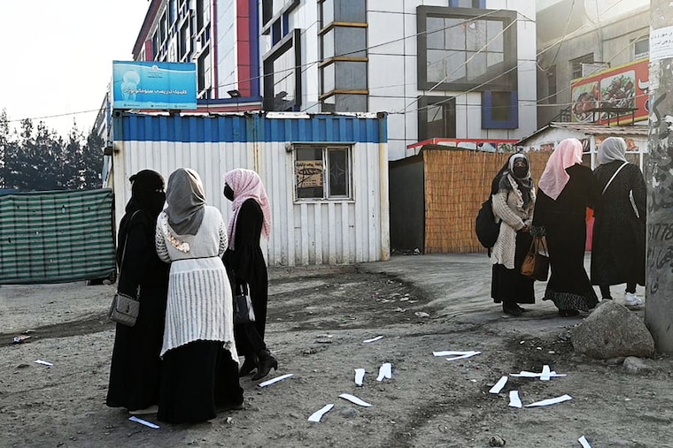 Afghan female university students walk on their on way back home past a private university in Kabul, on December 21, 2022. Afghanistan"s Taliban rulers have banned university education for women nationwide, provoking condemnation from the United States and the United Nations over another assault on human rights. Image: Wakil Kohsar/AFP