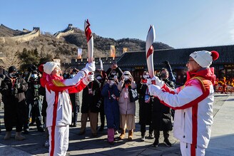 Torchbearers Wu Jingyu, a two-time gold medallist in taekwondo, and actor Jackie Chan relay the Olympic flame at the Badaling section of the Great Wall in Yanqing district.