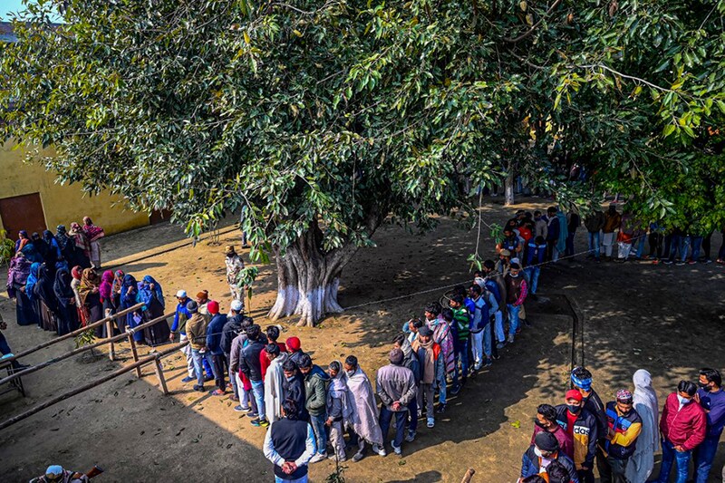 Voters queue up to cast their ballot at a polling station in Meerut on February 10, 2022, during the first phase of the Uttar Pradesh state assembly elections.