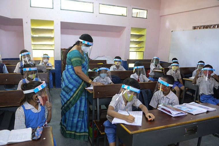 Students wearing facemasks and face-shields attend a class after the reopening of schools, closed as a preventive measure to curb the spread of the Covid-19, at a government primary school in Hyderabad on February 11, 2022.
