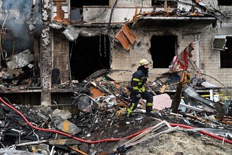 Firefighters work at a damaged residential building at Koshytsa Street, a suburb of the Ukrainian capital Kyiv, where a military shell allegedly hit, on February 25, 2022. - Invading Russian forces pressed deep into Ukraine as deadly battles reached the outskirts of Kyiv, with explosions heard in the capital early Friday that the besieged government described as "horrific rocket strikes". The blasts in Kyiv set off a second day of violence after Russian President Vladimir Putin defied Western warnings to unleash a full-scale ground invasion and air assault that quickly claimed dozens of lives and displaced at least 100,000 people. Image: Genya Savilov / AFP
