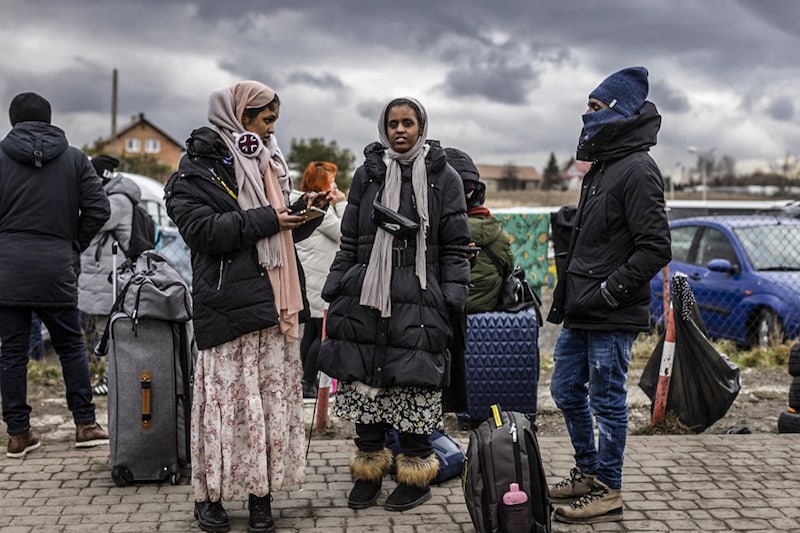 Indian students wait for transport as refugees from many different countries—from Africa, the Middle East and India—mostly students of Ukrainian universities, arrive at the Medyka pedestrian border crossing, fleeing the conflict in Ukraine, in eastern Poland on February 27, 2022. As Ukraine braces for a feared Russian invasion, its neighbours, EU members, are making preparations for a possible influx of hundreds of thousands or even millions of refugees fleeing military action.