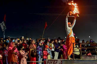 A priest performs evening prayers at the Sangam, the confluence of rivers Ganges, Yamuna, and the mythical Saraswati on the occasion of the New Year Day in Prayagraj on January 1, 2022.