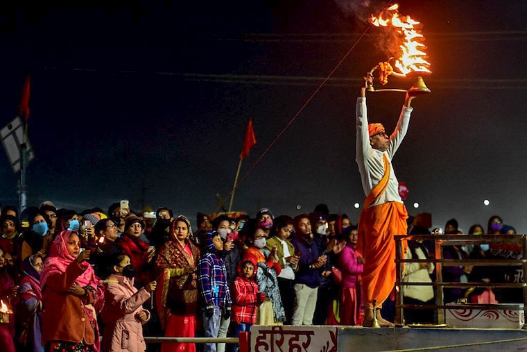 A priest performs evening prayers at the Sangam, the confluence of rivers Ganges, Yamuna, and the mythical Saraswati on the occasion of the New Year Day in Prayagraj on January 1, 2022.